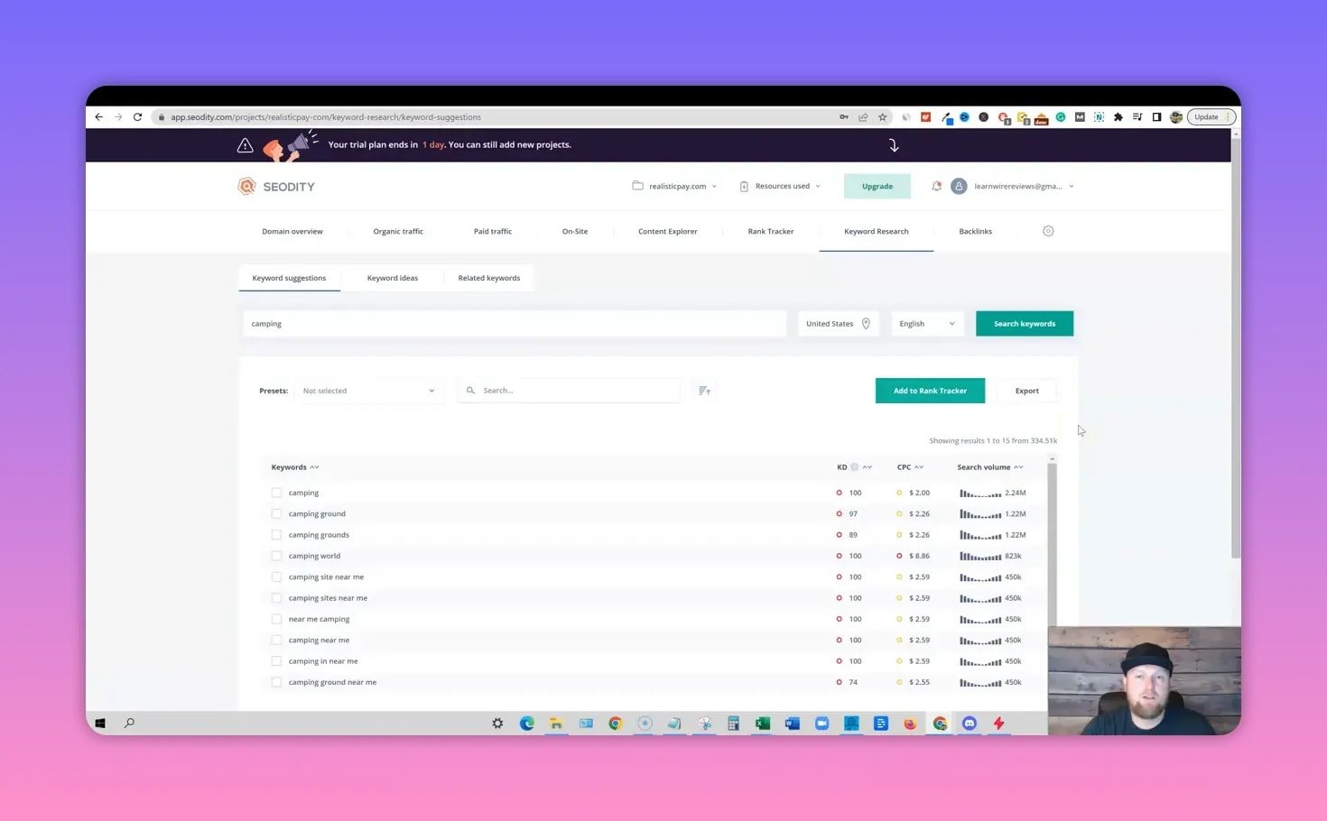 Clear SEODITY keyword research screen for the query 'camping' showing a list of related keywords with KD, CPC and search volume graphs; presenter thumbnail visible bottom-right.